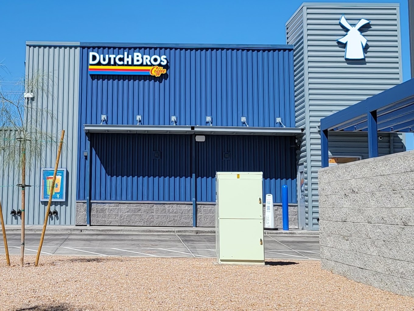 An outside view of a Dutch Bro's Building, blue and grey siding with a sign that says "Dutch Bros"