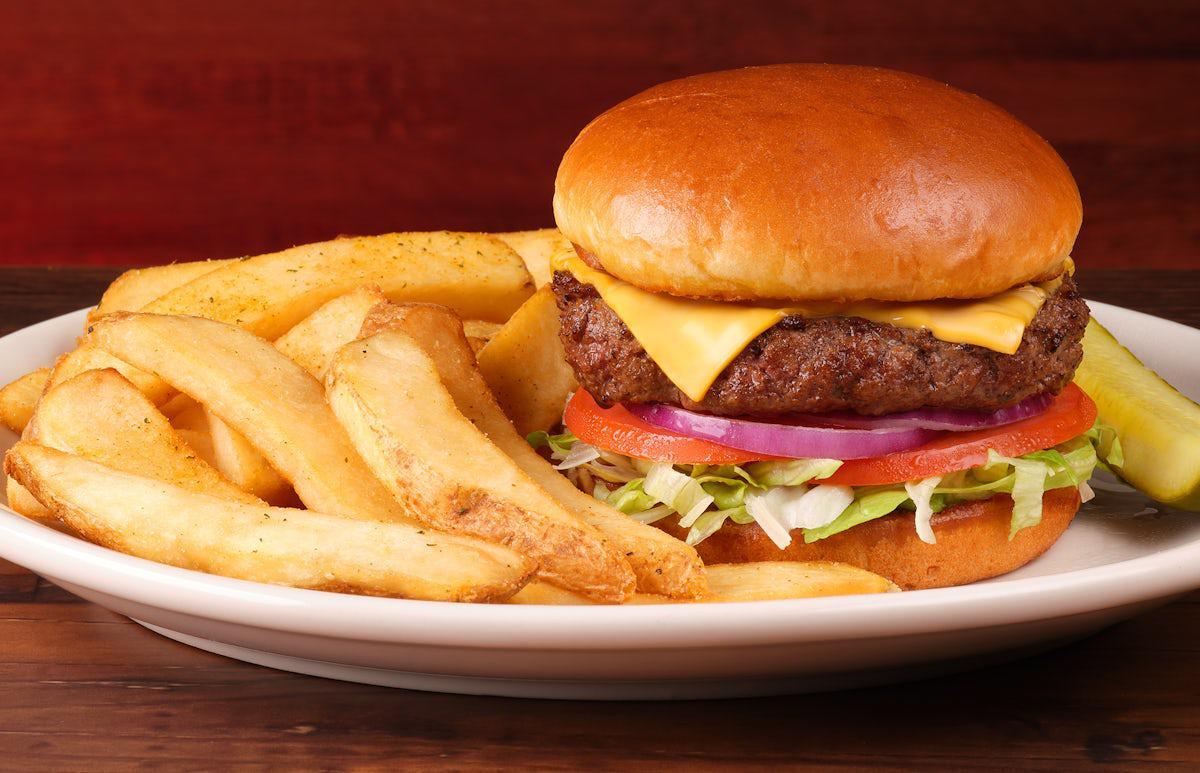 A Texas Roadhouse Burger on a white plate with a side of regular cut fries.