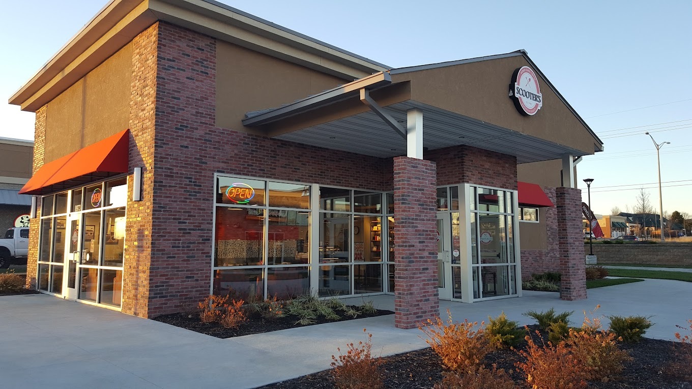 A brown and brick building with red accenting. An awning above the door has a sign reading "Scooter's" in red, white and black.