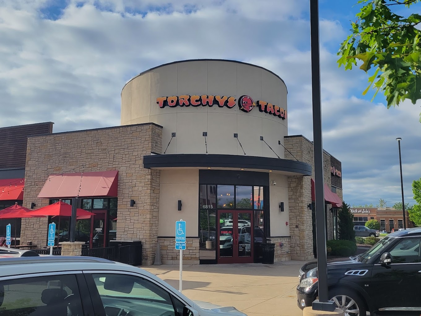 A beige round shaped building with red lettering above the door reading "Torchy's Tacos"