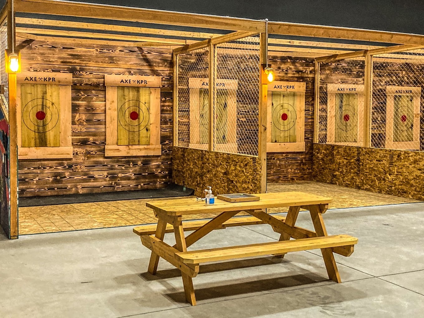 A view of axe throwing targets along with a picnic table sitting area.