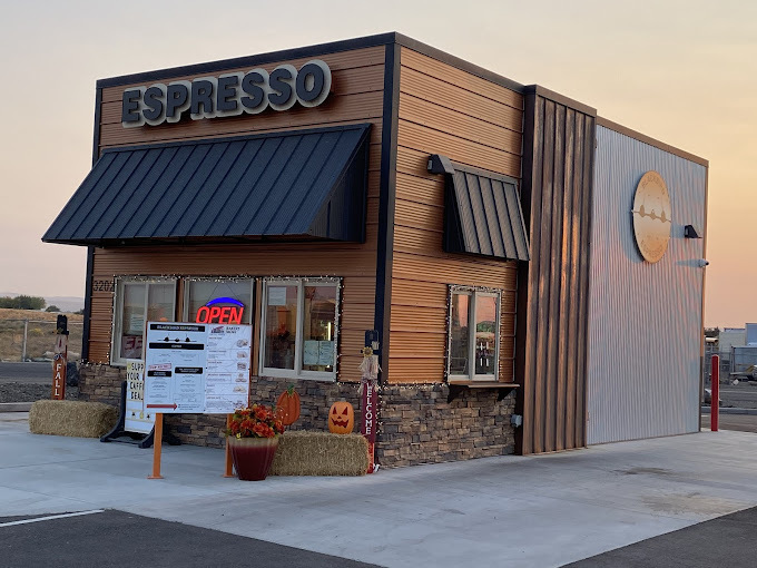 A small drive-in coffee shop with an large sign with "Espresso"