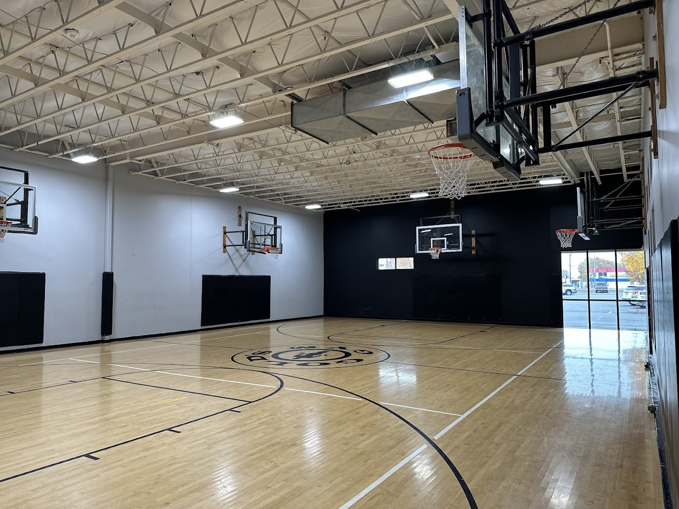 A large gym with a black and white walls with basketball hoops.