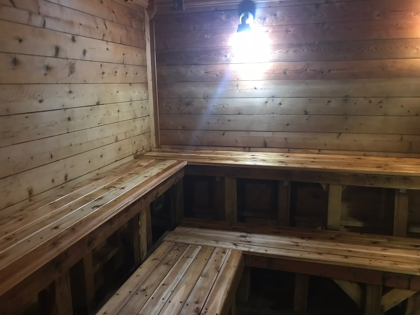 An inside view of a wooden sauna with a single white.