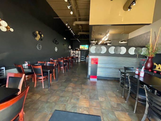 A view of a restaurant with a beige walls, a large sitting area.