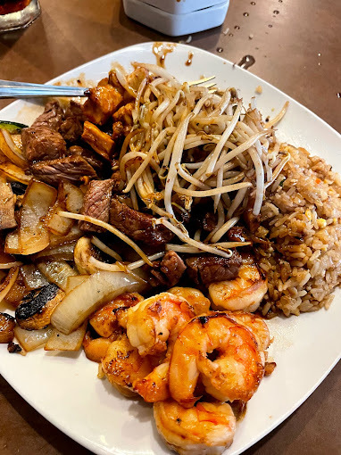 Close view of shrimp, noodles, and rice on a white plate.