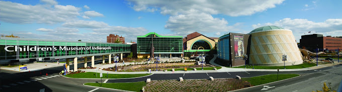 Wide angle view of the Children's Museum exterior, which has green glass windows and beige columns.