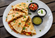 Golden grilled quesadilla wedges filled with melted cheese and seasoned chicken, served with salsa verde, sour cream, and fresh pico de gallo.
