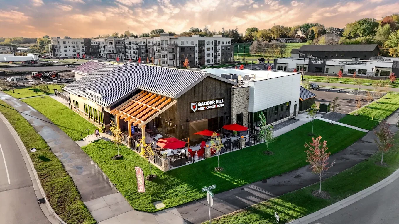 An outside view of a large brewing company, black siding and an awning on the side of the building made of wood.