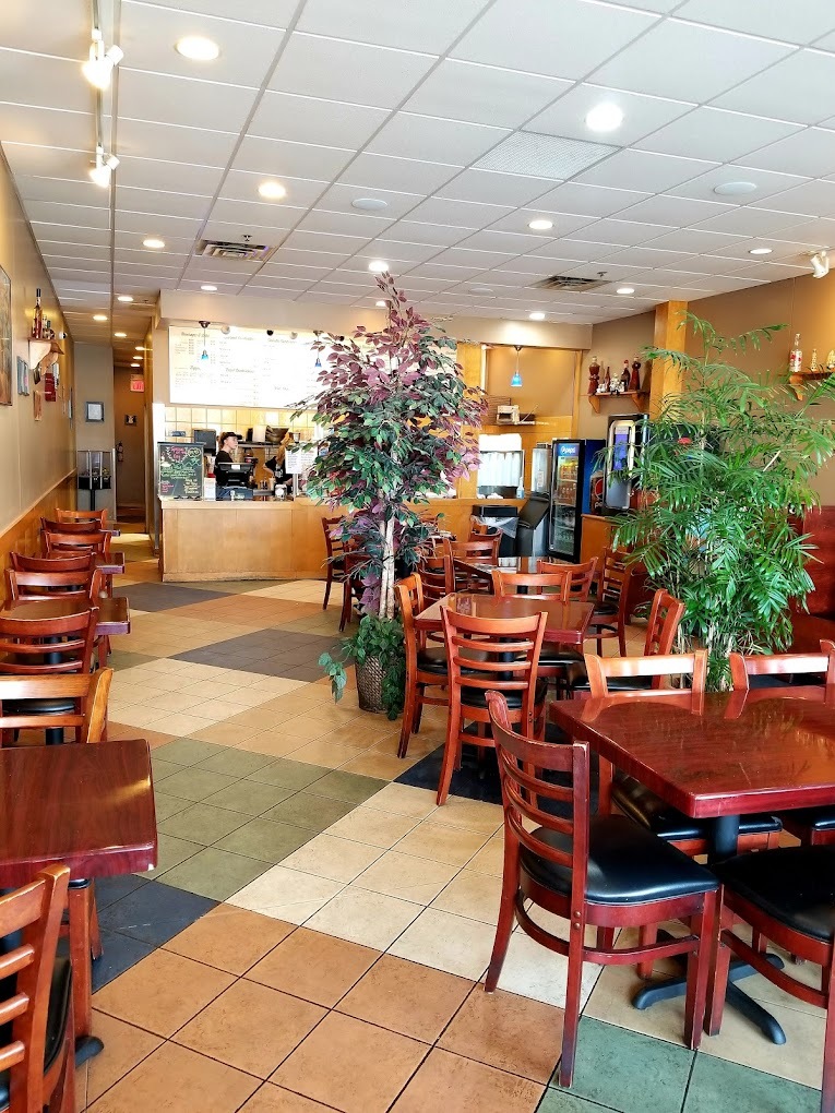 An inside view of a seating area in a café with greenery and soft warm lighting.