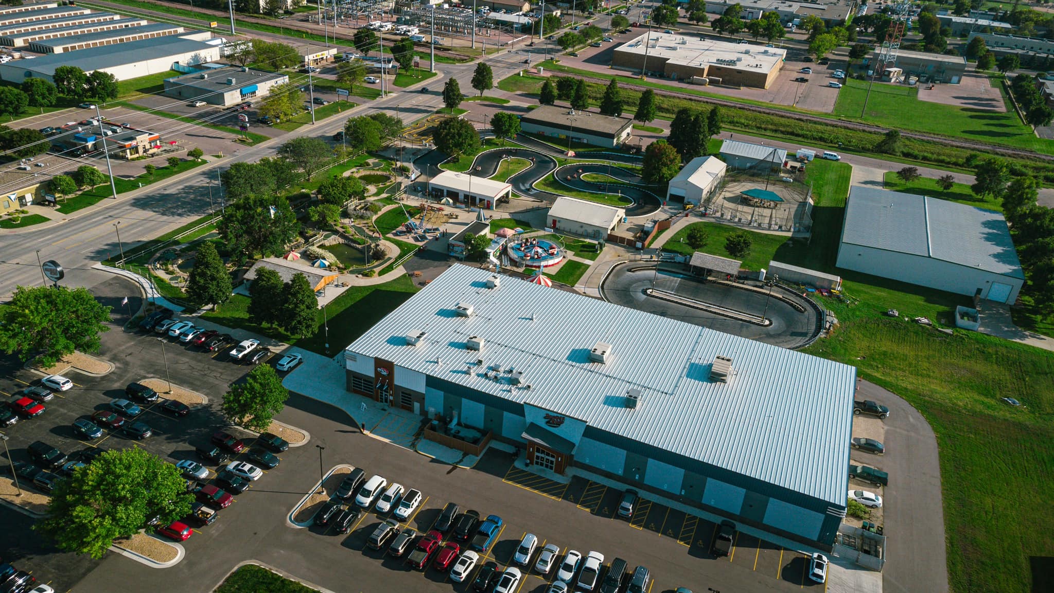 Aerial view of the Thunder Road landscape. There are two large buildings, a parking lot, mini-golf, and go-kart tracks.