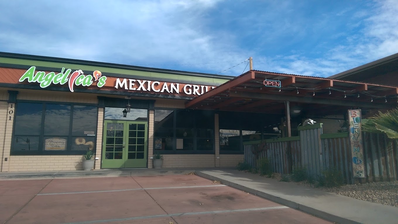 A green and tan colored building with a lighting patio, green doors and a sign above the doors also in green reading "Angelina's Mexican Grill"