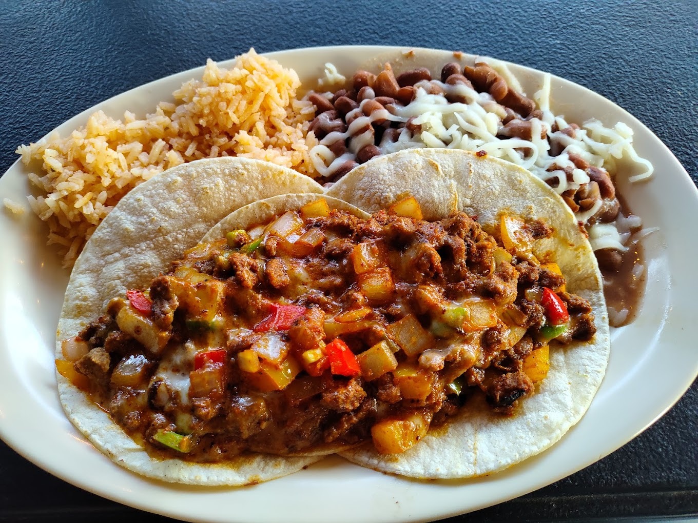 House made taco with rice and beans on a white plate.