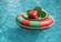 Colorful bumper boat floating on clear turquoise water under bright daylight with gentle ripples surrounding the boat.
