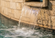 Close-up of a stone water feature with a smooth sheet of cascading water flowing into a bubbling pool below.