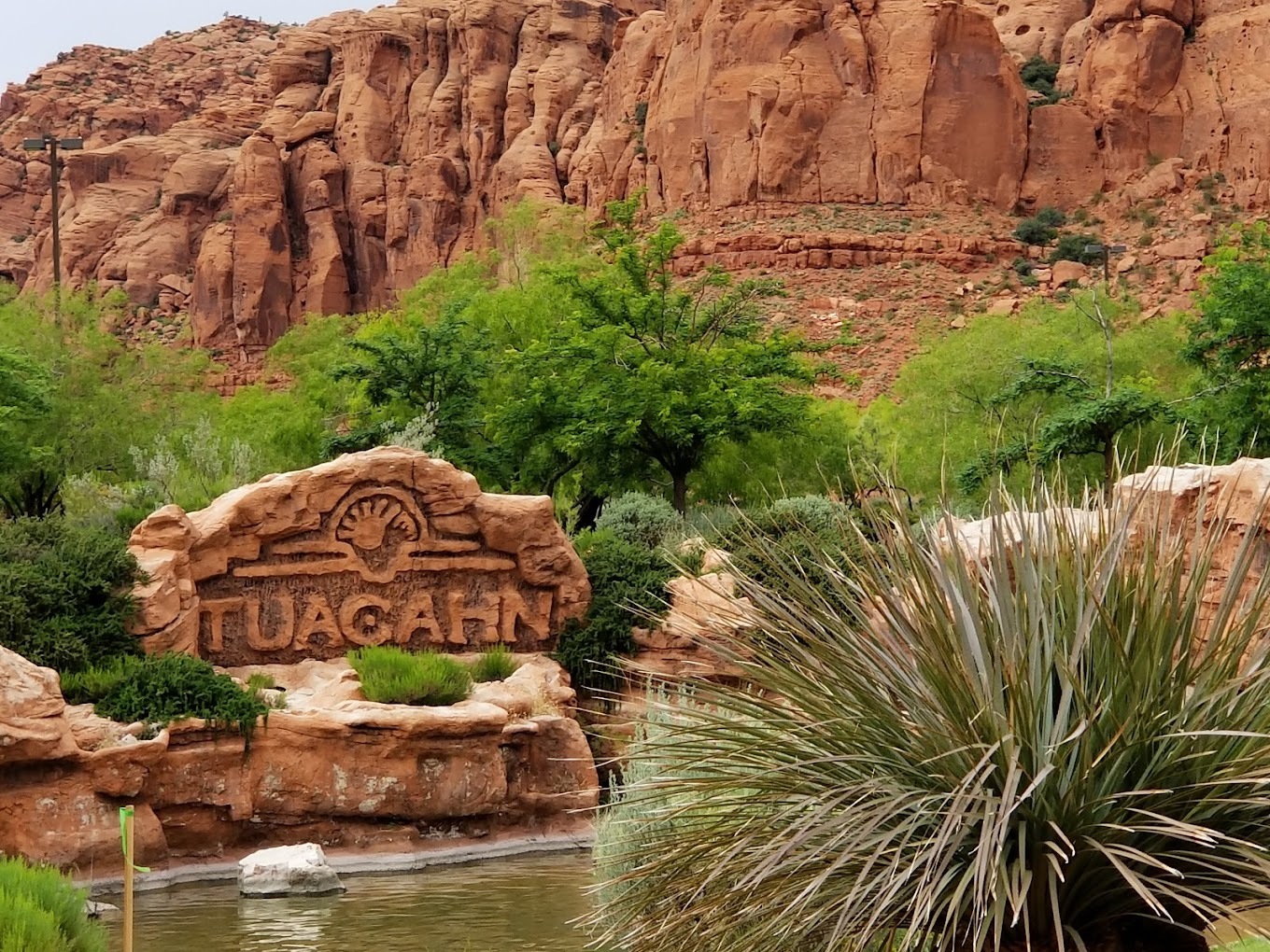 Red rock canyon with a red rock sign carved out with the words "Tuacahn"