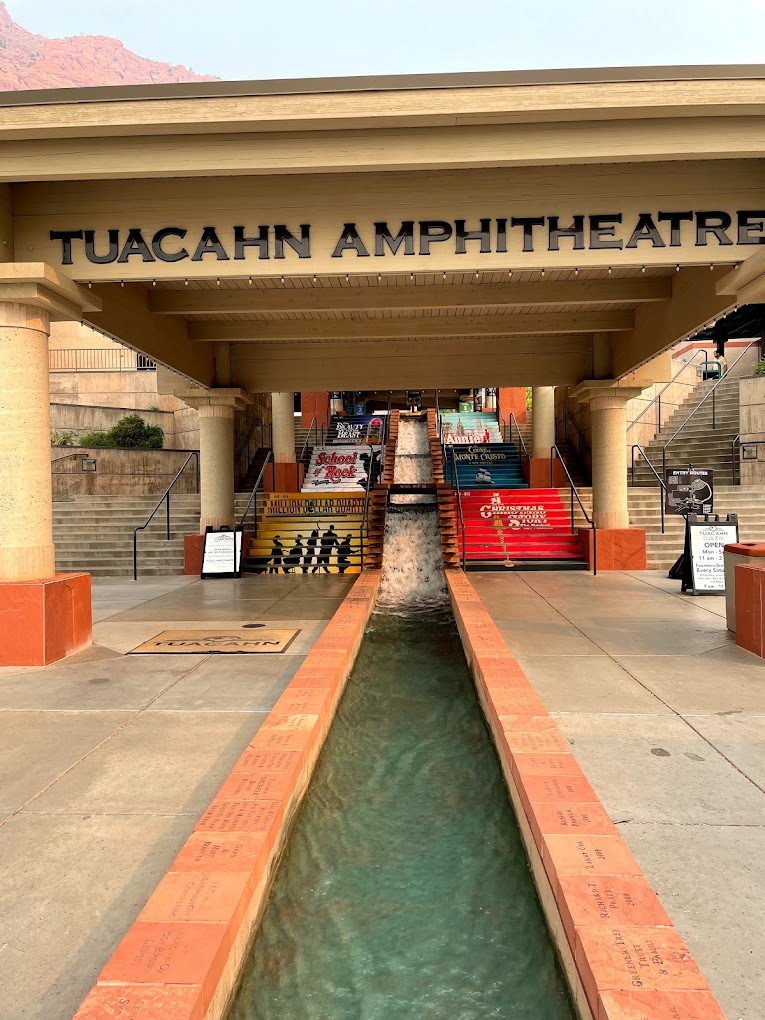 A stone gazebo with the words Tuacahn Ampitheatre with water feature flowing through the middle
