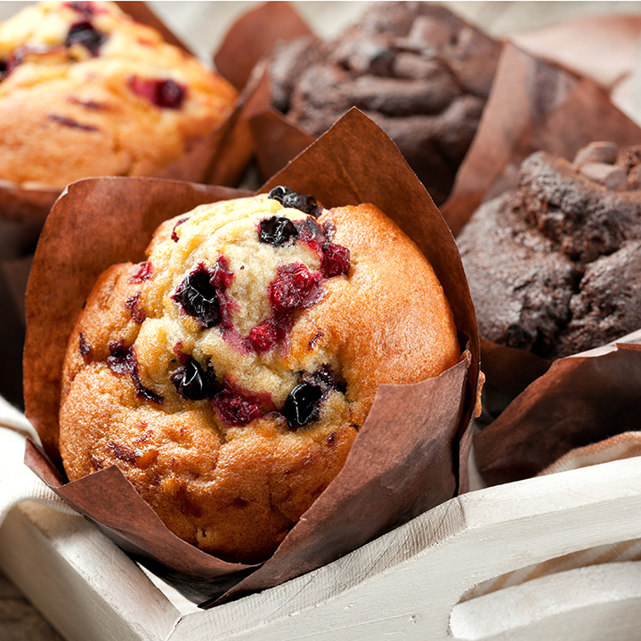 A close up of a white tray consisting of berry muffins and double chocolate chip muffins.
