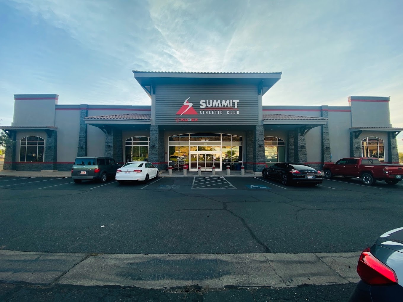 Large grey and white building with a sign reading "Summit Athletic Club" in red and white lettering.