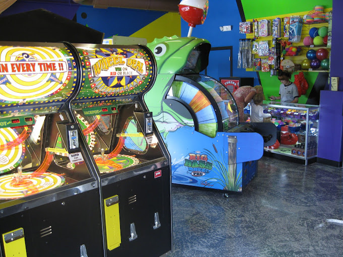 An view of a game room filled with many different lighted arcade games.