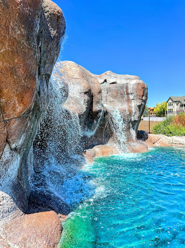 An view of a very large water feature and a large rock formation and waterfall.