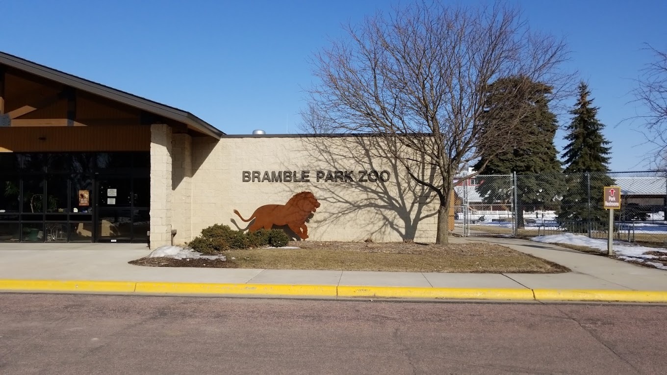 A view of a building with a sign offset reading "Bramble Park Zoo"