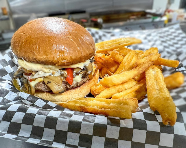 A view of a basket with a large cheese burger and a side of fries.