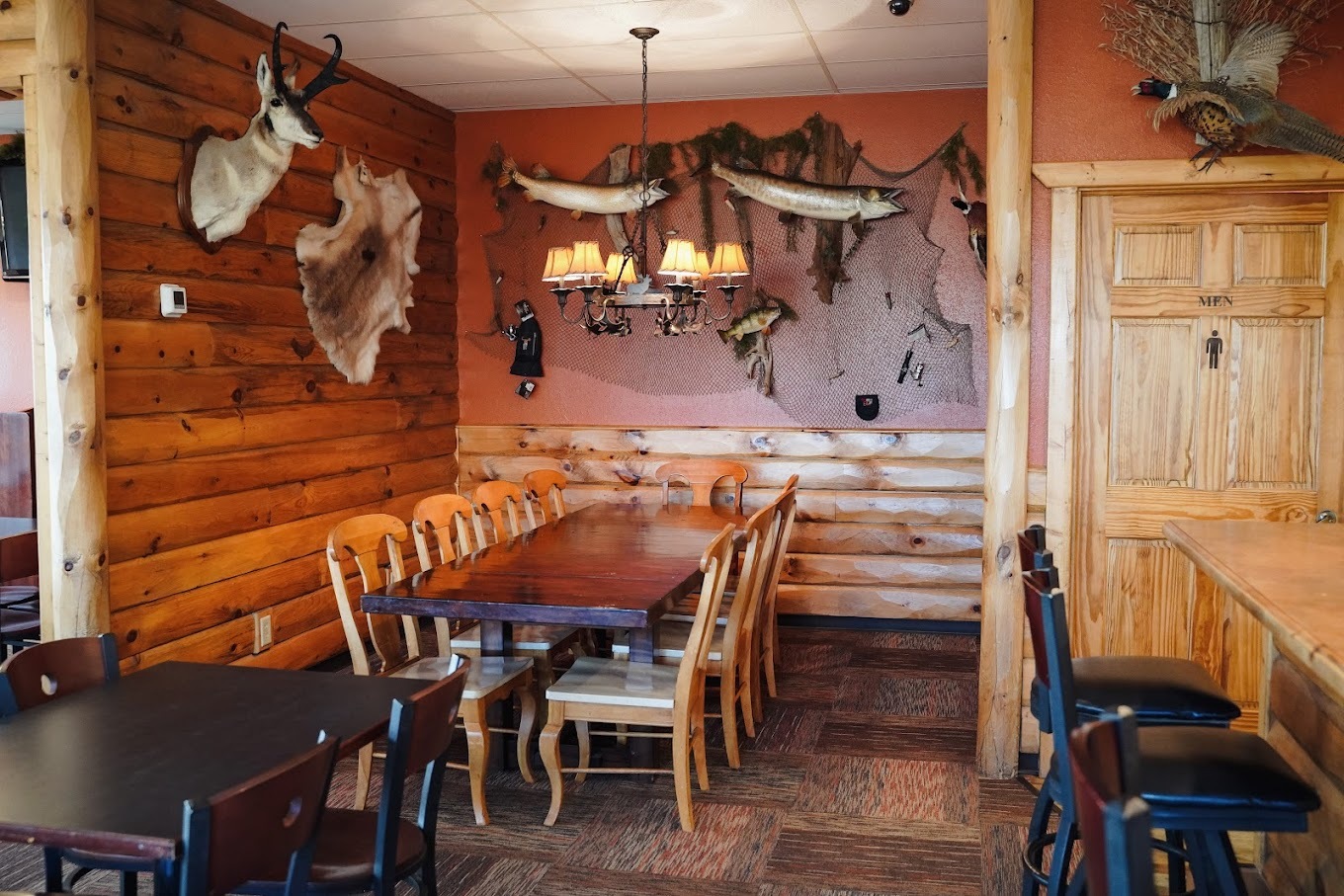 A inside view of a restaurant with animal busts on the wall.